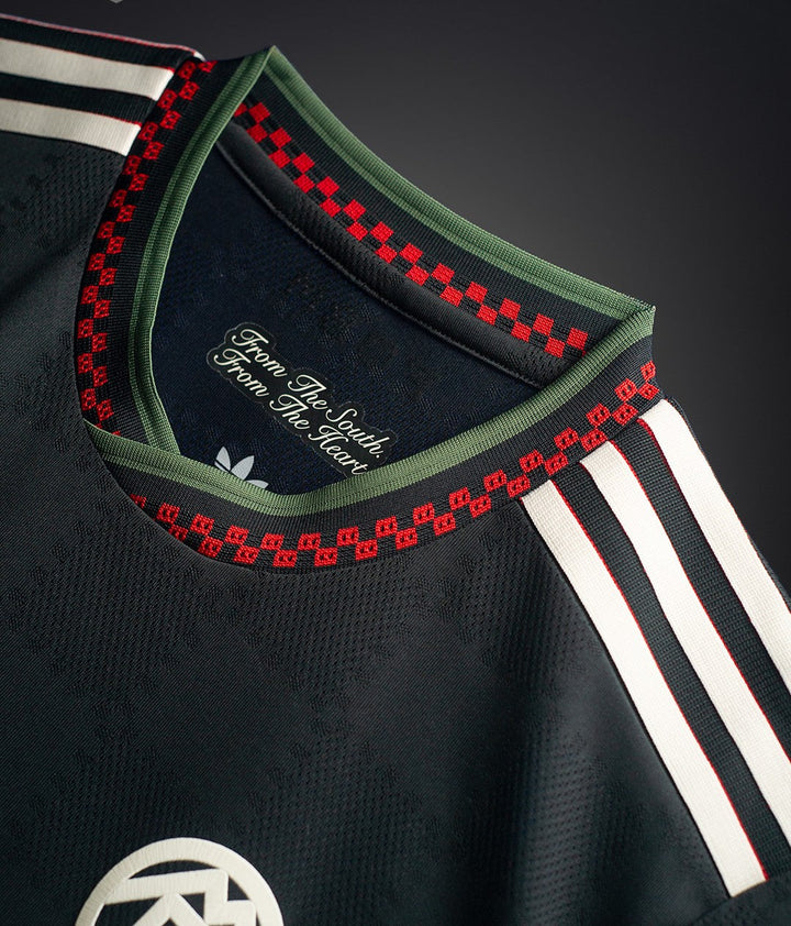 Striker Store Bayern Munich third jersey 2025-26 black close up showing green collar red checker trim and white shoulder stripes