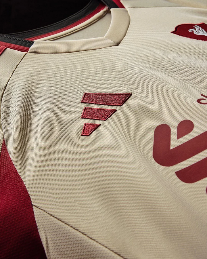 Striker Store close up of Liverpool Away Jersey 2025-26 cream fabric with maroon trim and embroidered logos