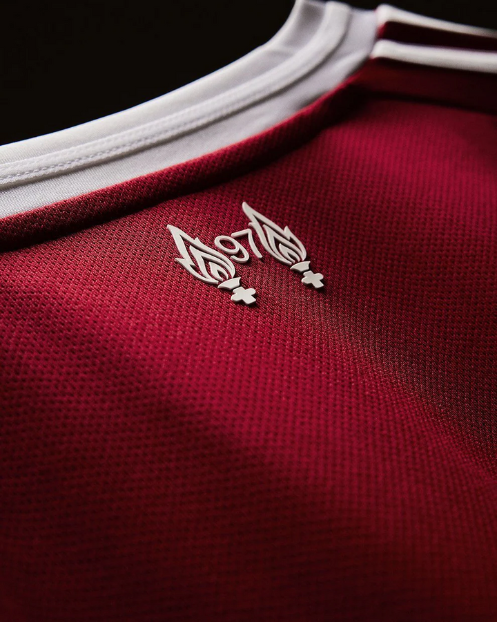 Striker Store close up of Liverpool home jersey 2025-26 full sleeves red textured fabric white collar emblem