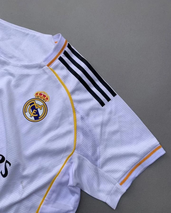 Striker Store Real Madrid 2025 home jersey white mesh with club crest black shoulder stripes and gold trim