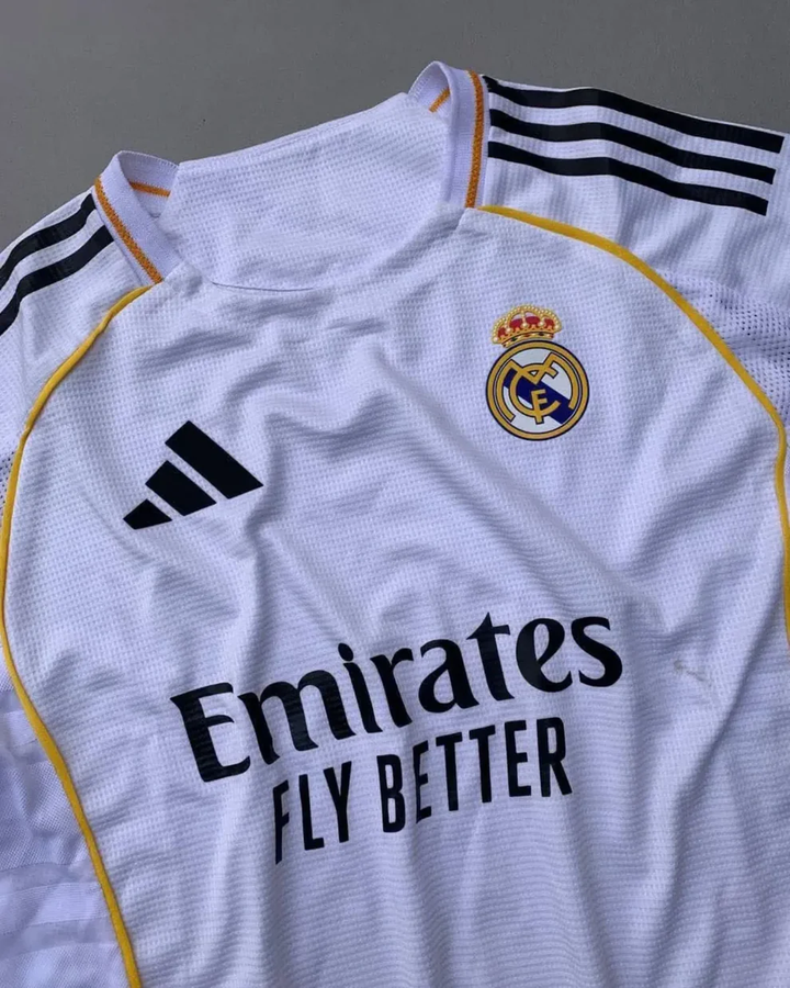 Real Madrid 2025 home jersey Striker Store white club kit with gold trim Adidas logo and Emirates sponsor