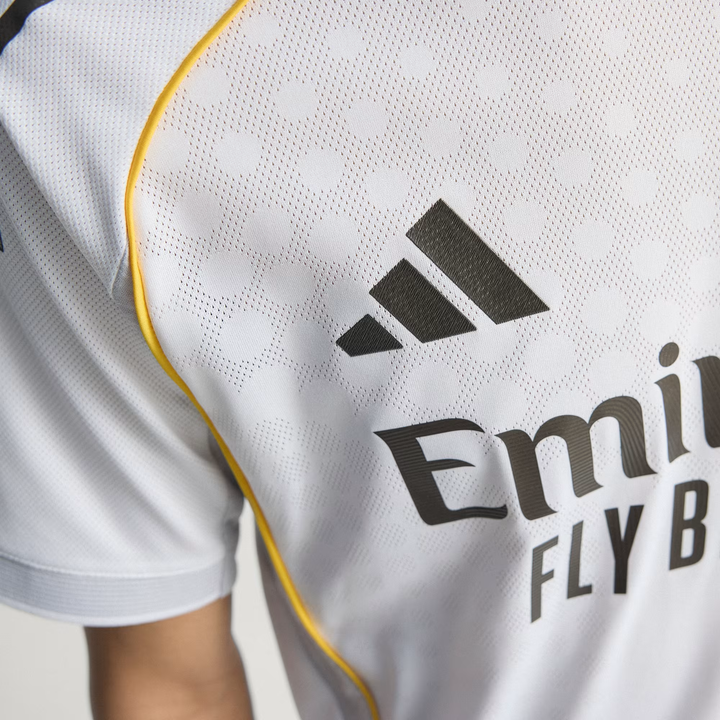 Close up of Real Madrid 2025 home jersey chest showing Adidas logo white fabric and yellow piping from Striker Store