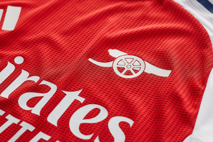 Close-up of Arsenal 2024 home jersey showcasing the iconic club logo and mesh fabric detail