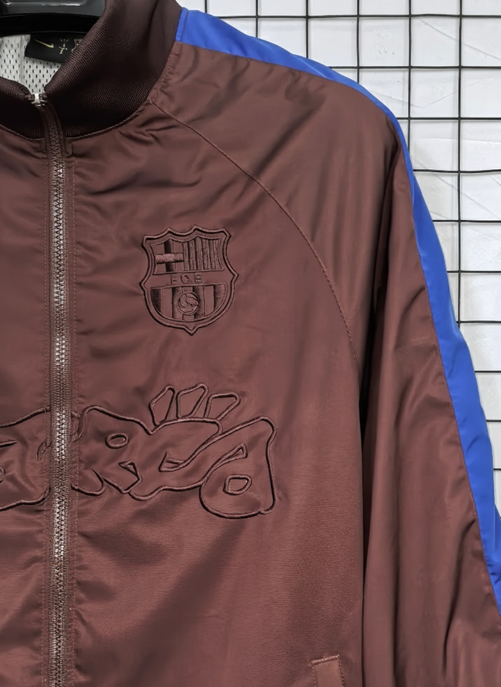 Barcelona Travis Scott windbreaker in brown with logo and blue accents for stylish outdoor wear