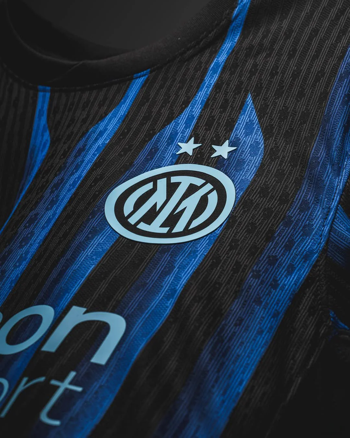 Close-up of Inter Milan 2025-26 home jersey by Striker Store showing blue and black stripes with club logo