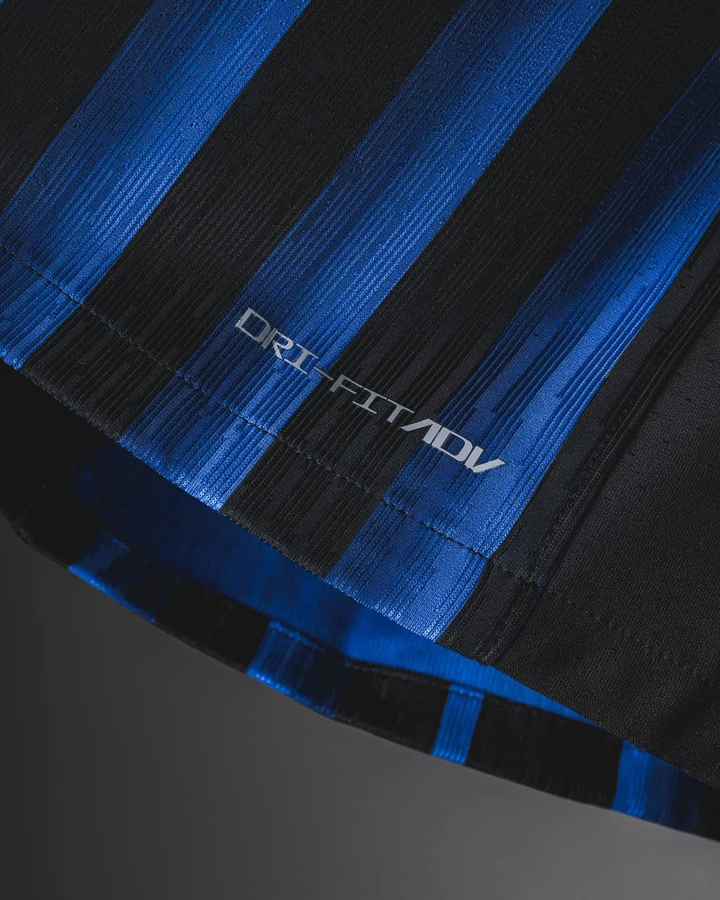Close-up detail of Inter Milan 2025-26 home jersey fabric with blue and black stripes and dri-fit ADV text
