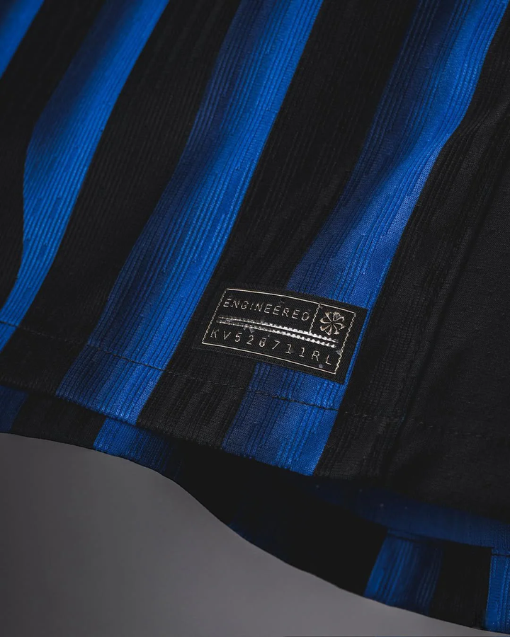 Close-up of Striker Store Inter Milan 2025-26 home jersey fabric with blue and black stripes and engineered label