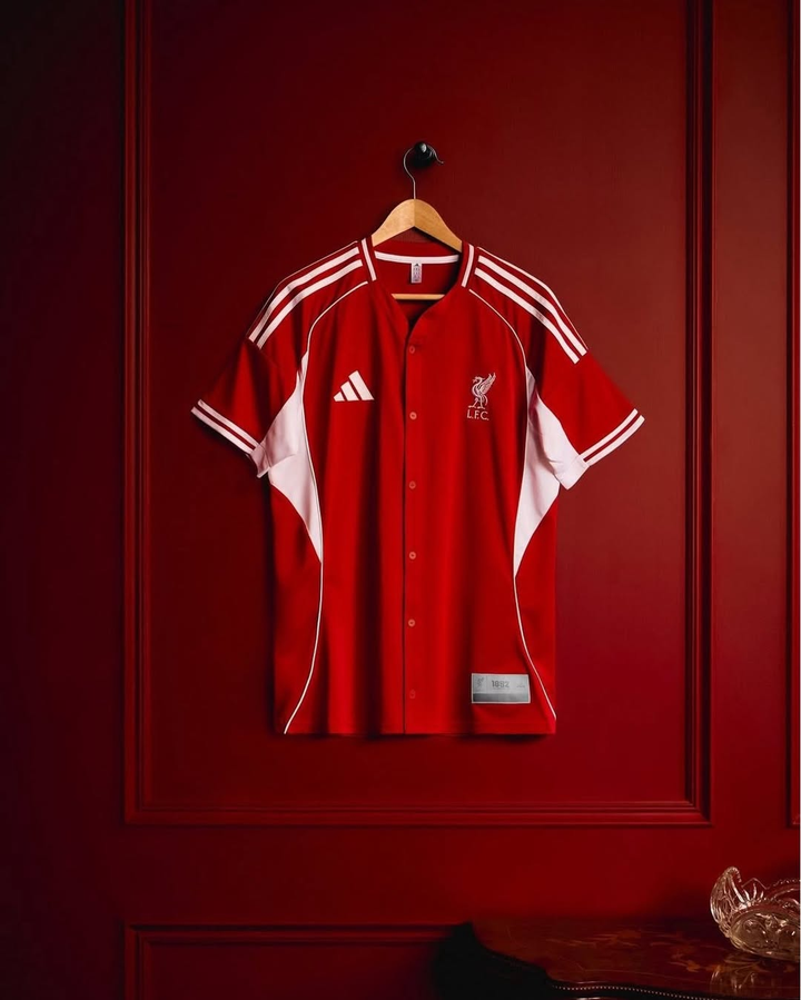Striker Store Liverpool US pack shirt 2025-26 in red with white accents displayed on a hanger