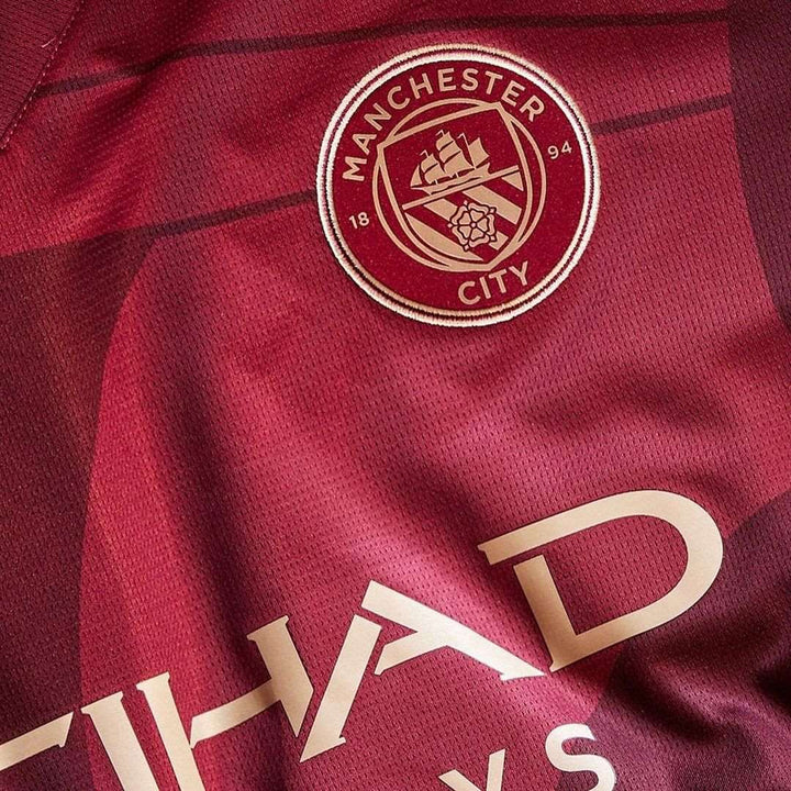 Close-up of Manchester City 2024 third jersey featuring the club logo and Etihad sponsor details