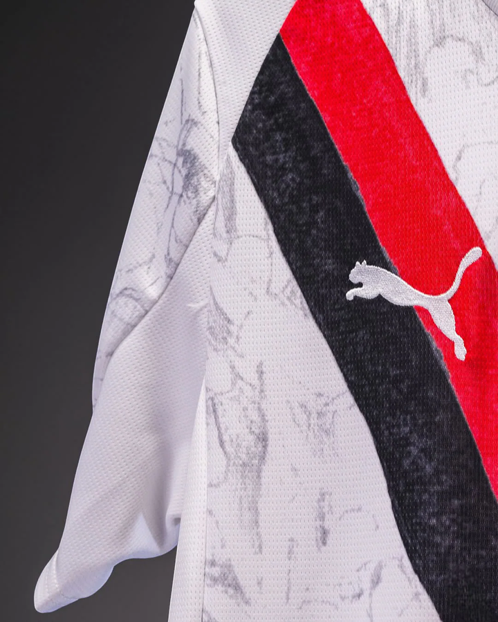 Striker Store Manchester City away jersey 2025-26 white fabric with red and black diagonal stripes and Puma logo