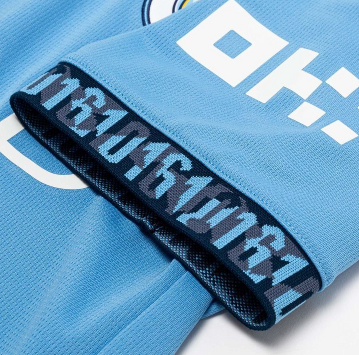 Close-up of Manchester City home jersey 2024 featuring detailed blue fabric and design elements
