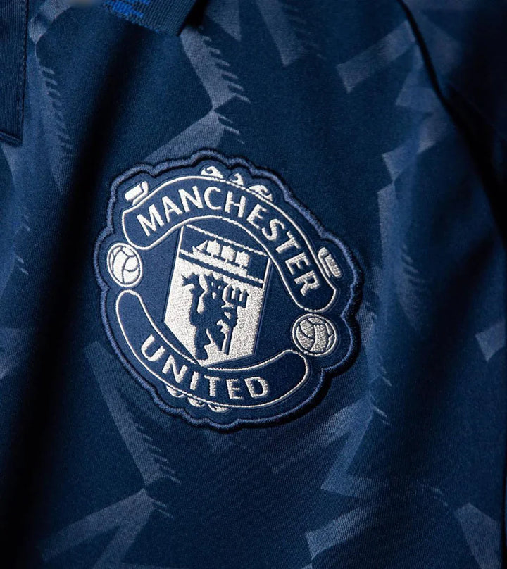 Close-up of the Manchester United 2024-25 away jersey badge featuring the club logo in detailed embroidery