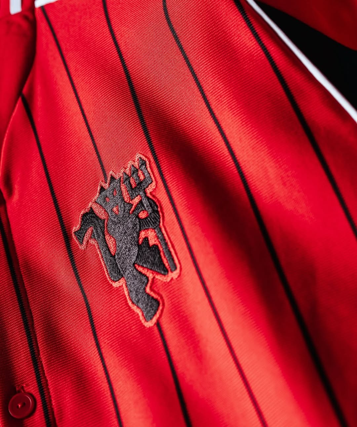 Close-up of the Manchester United special edition shirt 2025 showing the embroidered emblem on red fabric