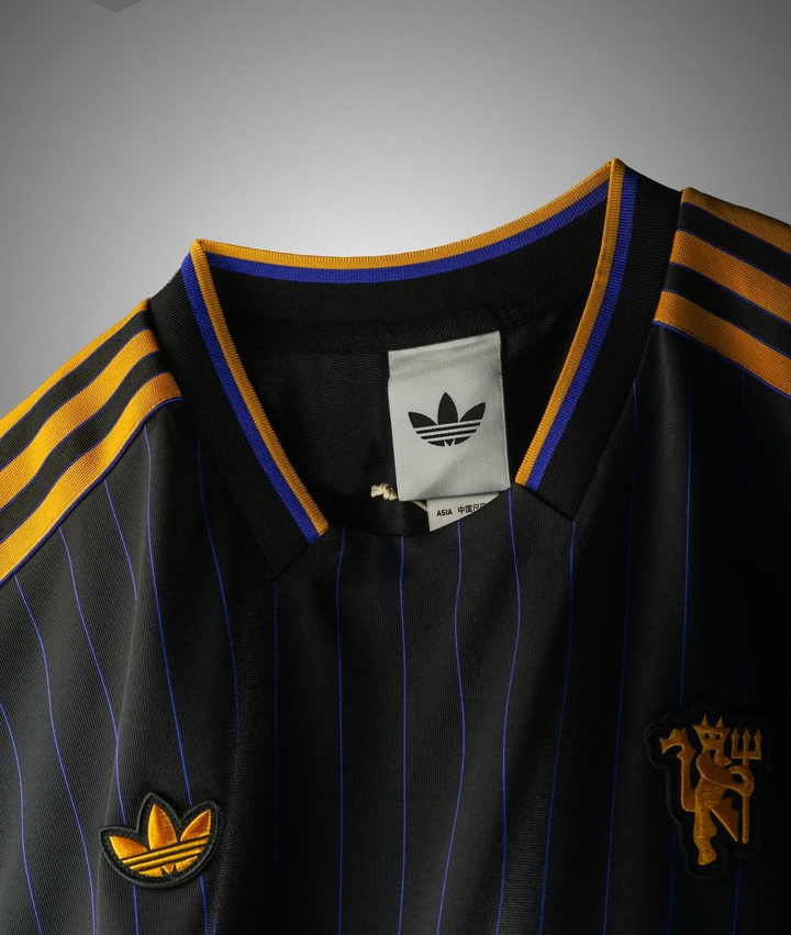 Striker Store Manchester United Terrace Icon jersey 2025-26 featuring black and gold design with classic stripes