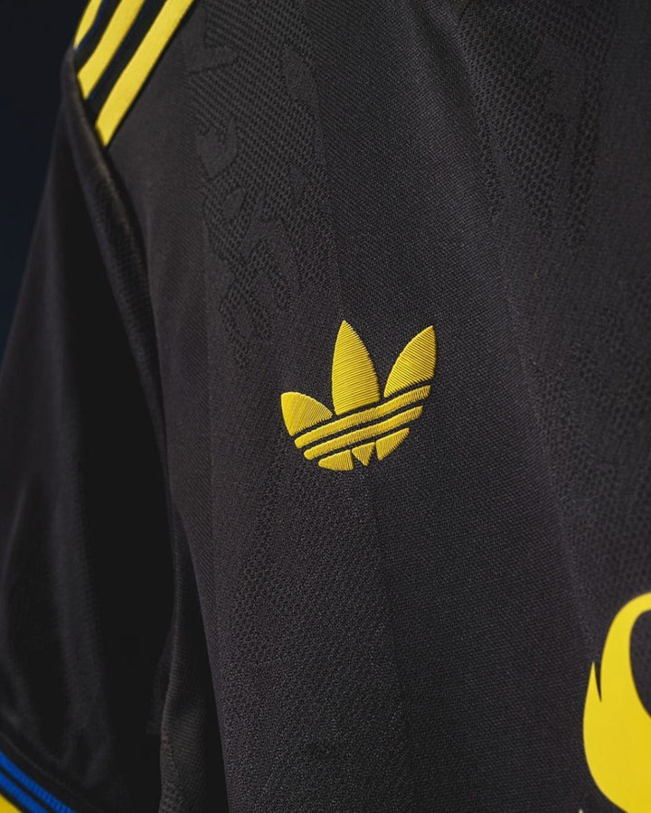 Close-up of the Adidas logo on the Manchester United third jersey 2025-26 with yellow accents