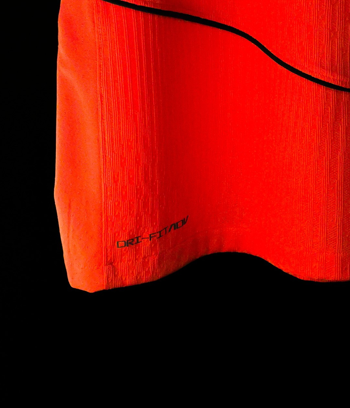 Striker Store close up of Barcelona third jersey 2025-26 player version orange red hem with black piping and DriFit texture