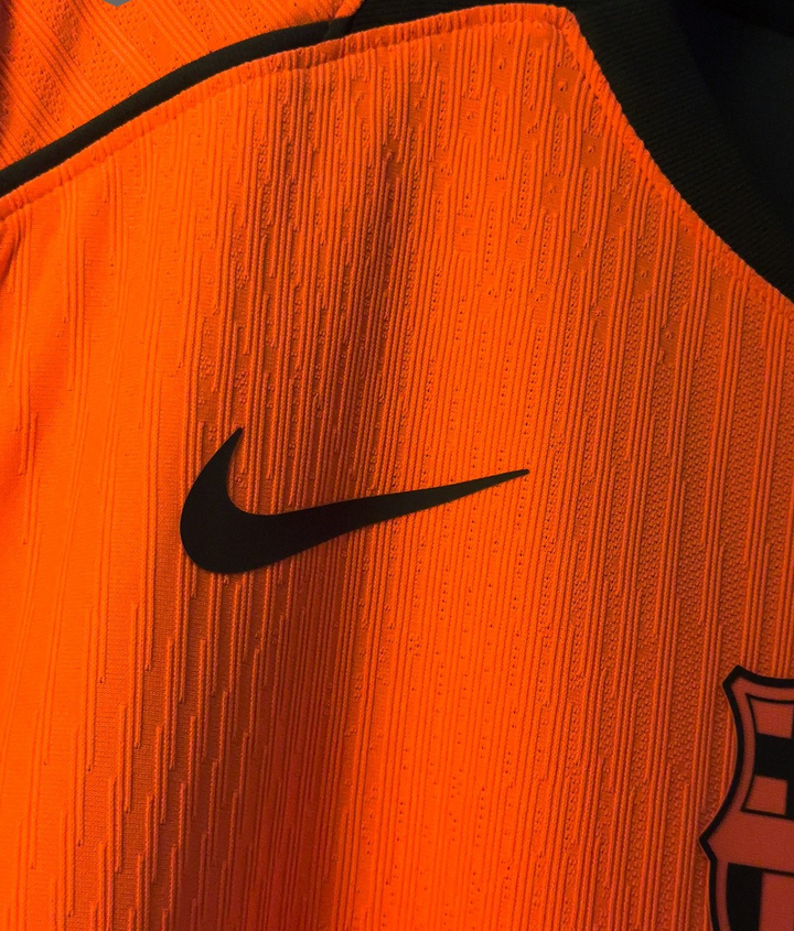 Striker Store Barcelona third jersey 2025-26 player version orange close up showing Nike swoosh and club crest