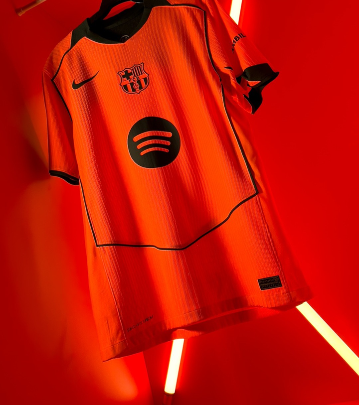 Striker Store Barcelona third jersey 2025-26 player version orange with black trim Nike and Spotify logos against red neon