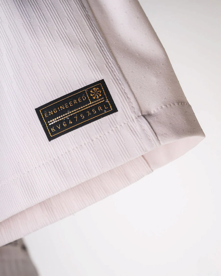 Close-up of Striker Store Chelsea away jersey 2025-26 with engineered fabric label on white material