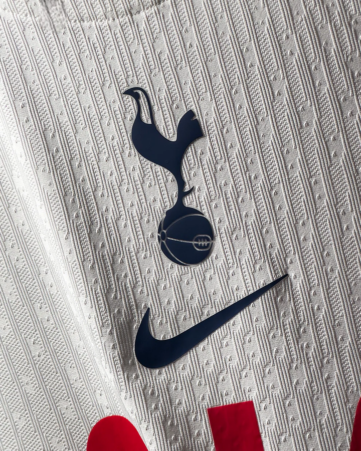 Tottenham Hotspur 2025 home jersey close up of white textured fabric with navy crest and Nike logo