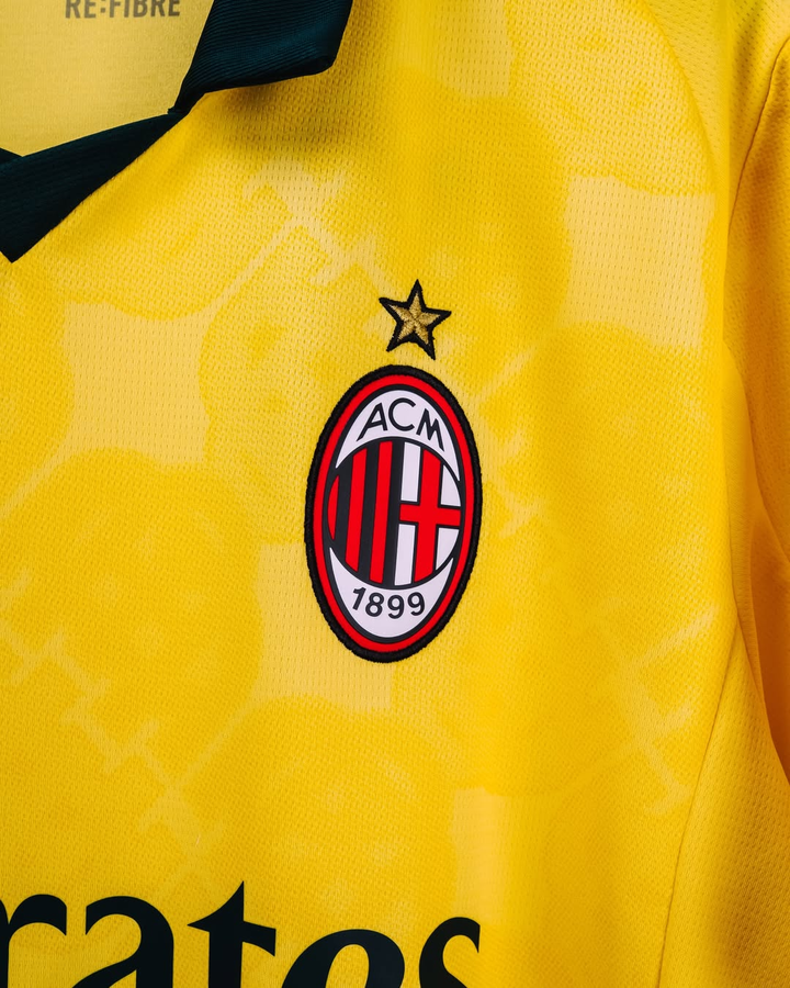 Striker Store yellow AC Milan 2025-26 third jersey pre order close up of club crest and black V collar
