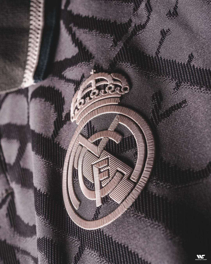 Close-up of Real Madrid 2024-25 player jersey featuring embroidered club emblem and modern design