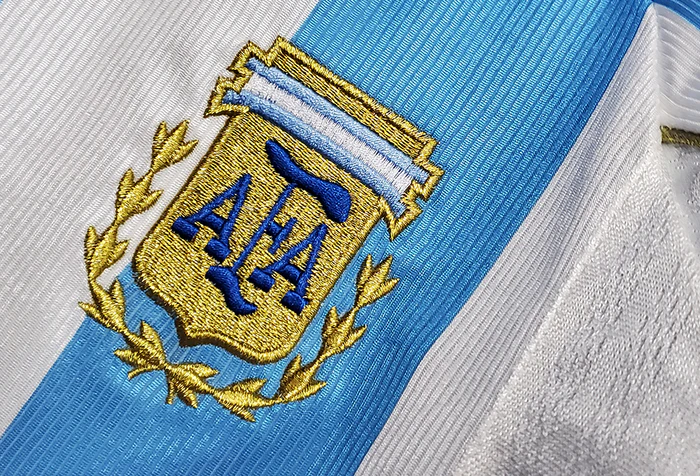 Close-up of Retro Argentina 1998 jersey featuring the embroidered AFA logo and blue and white stripes