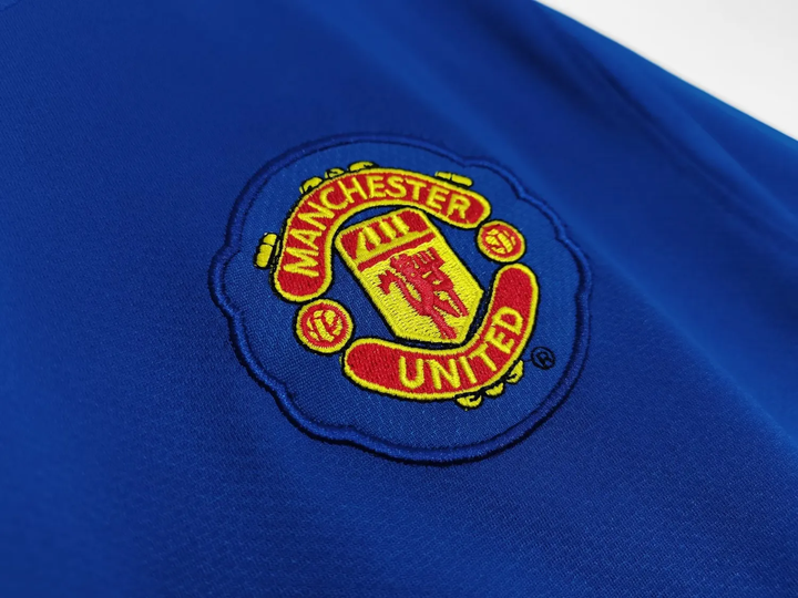 Close-up of Retro Manchester United jersey 2008-09 featuring the embroidered club crest in vibrant colors