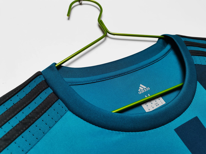 Retro Real Madrid 2017-18 jersey collar detail on a green hanger showcasing quality craftsmanship